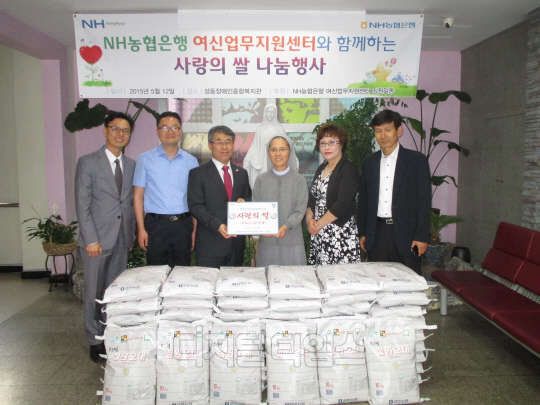한구병 NH농협은행 여신업무지원센터장(왼쪽 세 번째)이 최성자 복지관장(네 번째)에게 사랑의 쌀을 전달하고 있다.